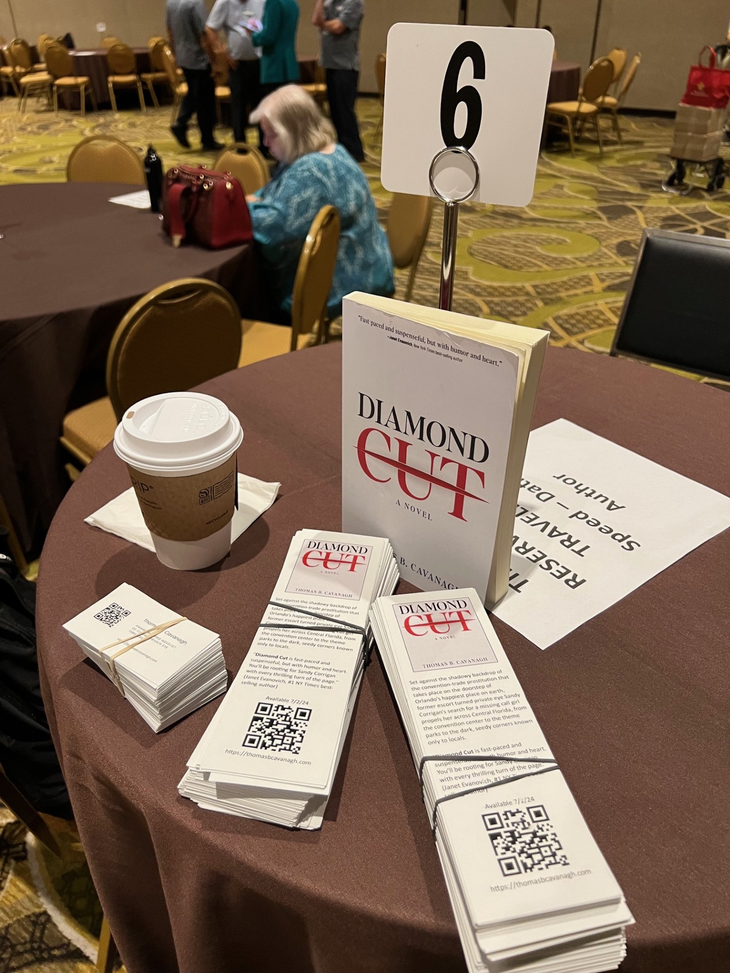 Diamond Cut book on a table with bookmarks and a coffee cup