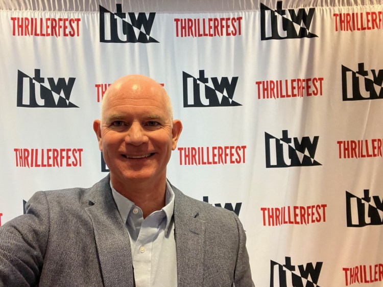 Tom in front of Thrillerfest banner